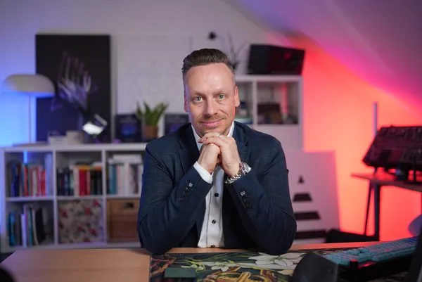 Fabian Henzler in a navy blazer at a desk, hands under his chin